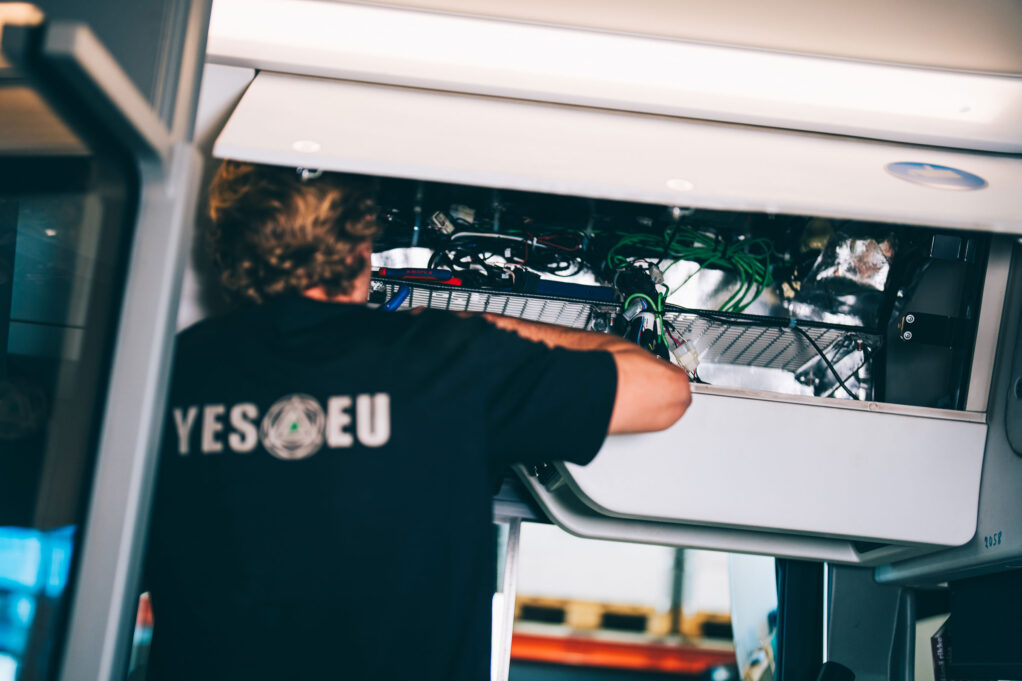YES-EU:n mekaanikko työskentelee ajoneuvon sähköjärjestelmän parissa